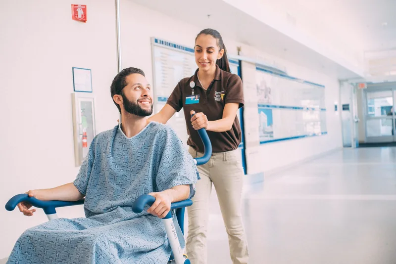 Care Navigator Scholar supporting a patient in a hospital hallway