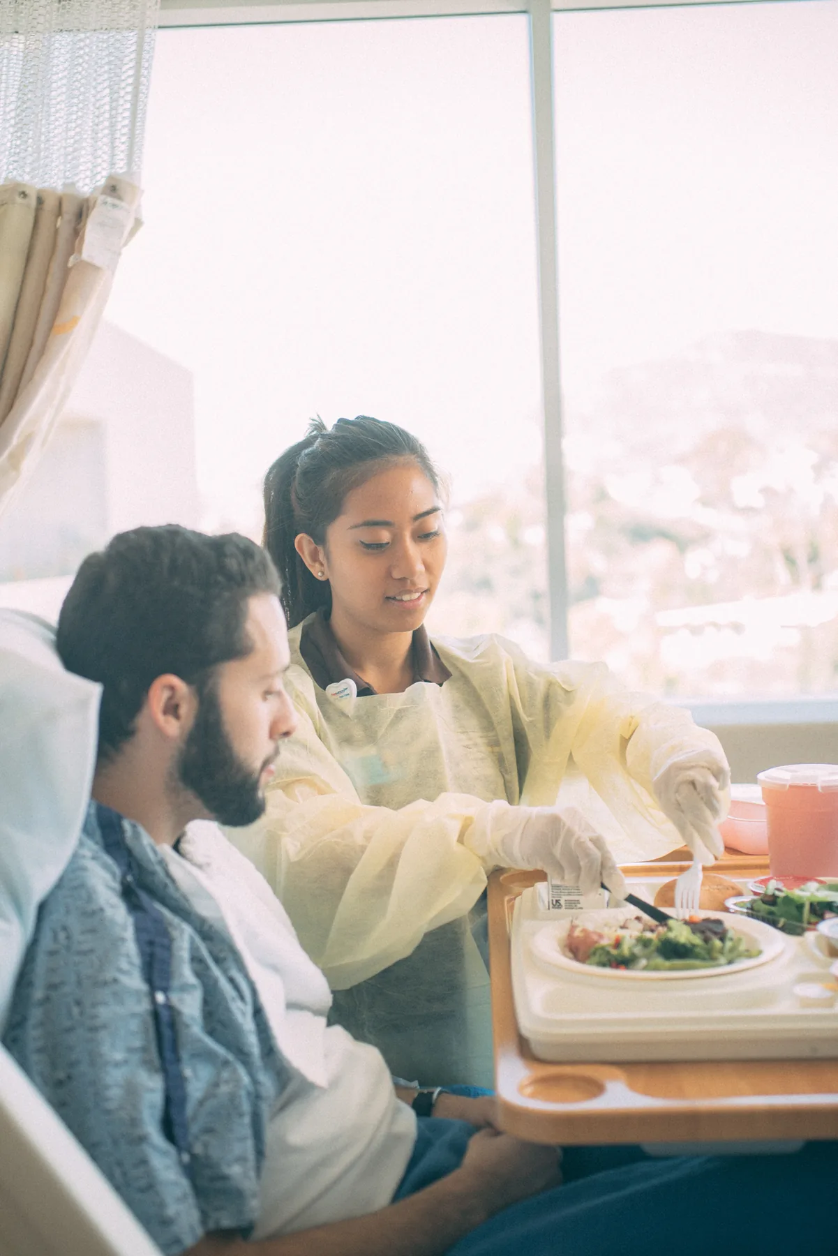 A Health Scholar assisting a patient with a meal